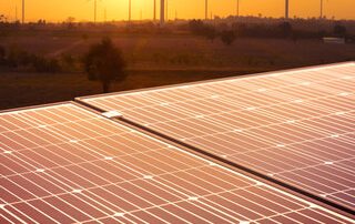 Solar panels and wind turbines representing energy and infrastructure projects with steel solutions